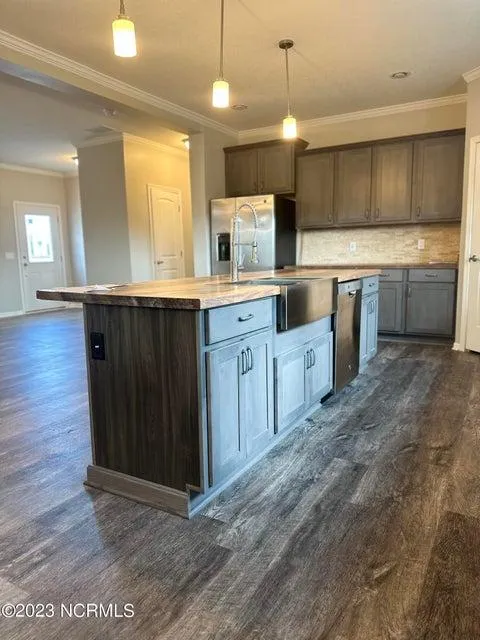 Picture of a table and refrigerator inside a nice home