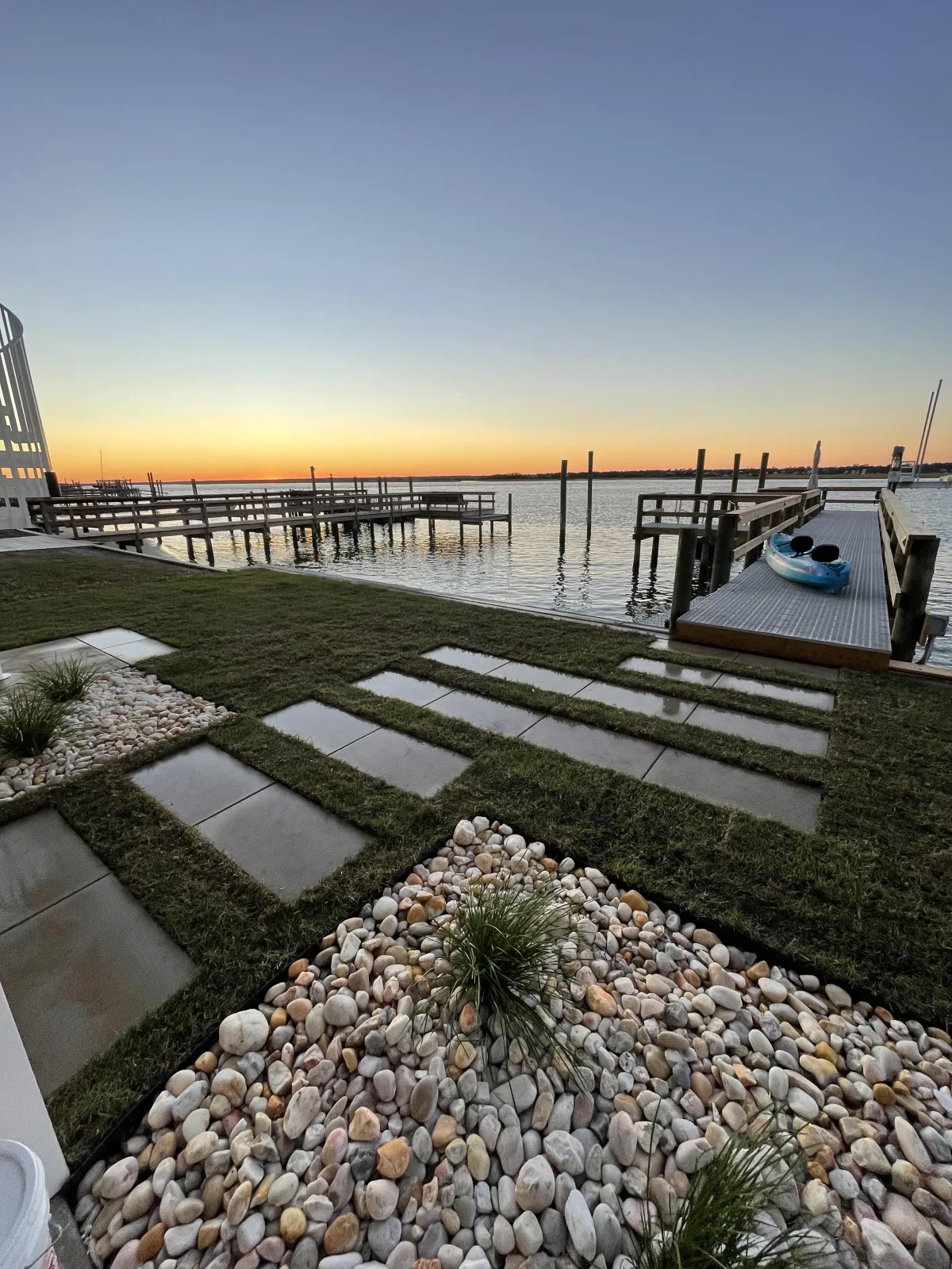 Modern outdoor kitchen with built-in grill and stone countertops.