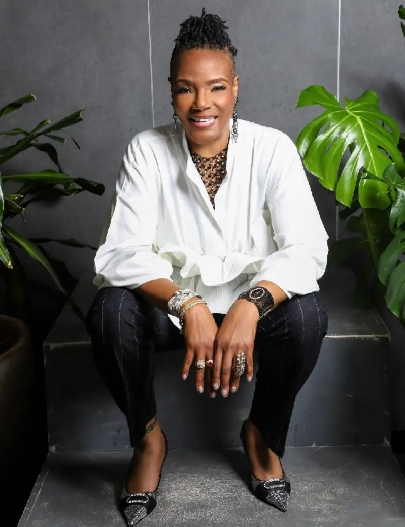 Confident business owner reviewing a digital self-audit on a tablet in a modern office, sunlight streaming through large windows, professional attire, focused expression, 3:2 aspect ratio