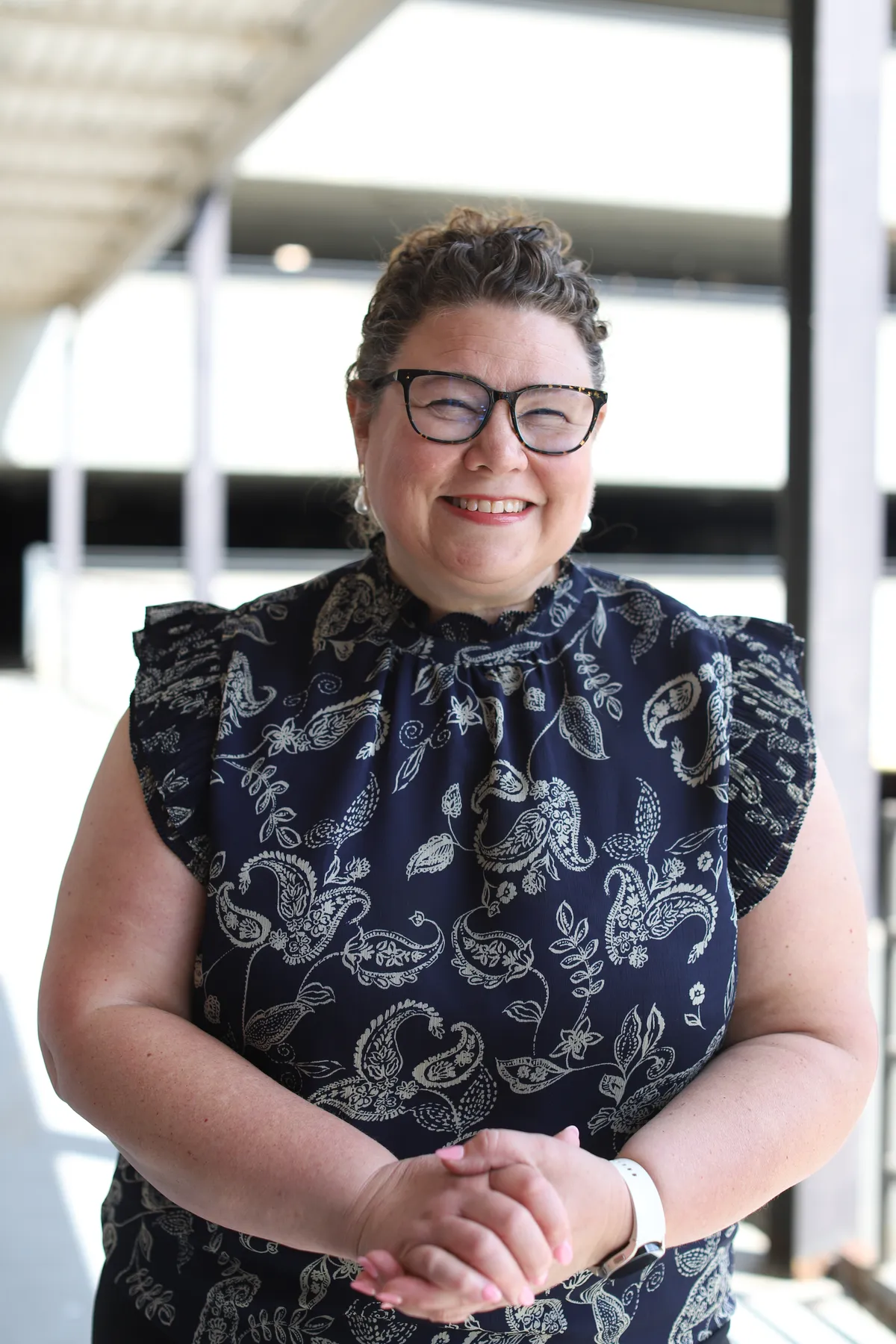 Amy Cummings, Christian women's leadership coach, smiling with her hands clasped
