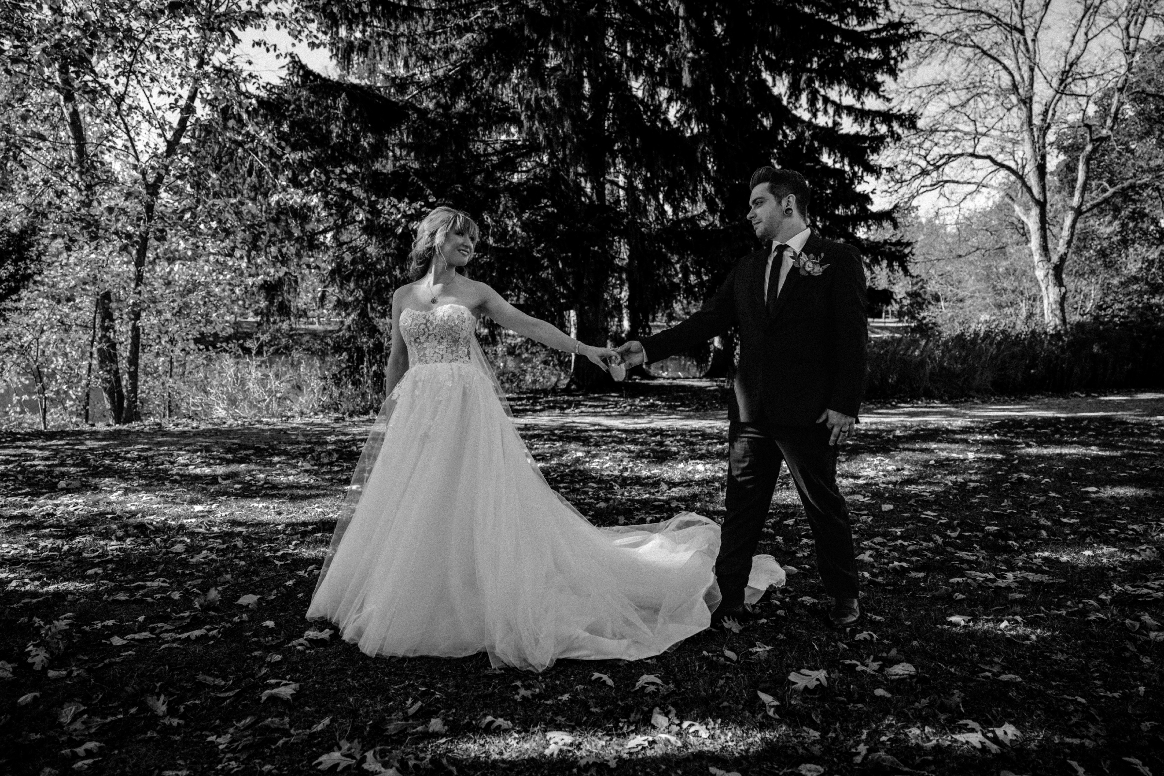 Documentary black and white wedding photo of a couple holding hands outdoors, photographed by a Northwest Ohio wedding photographer.