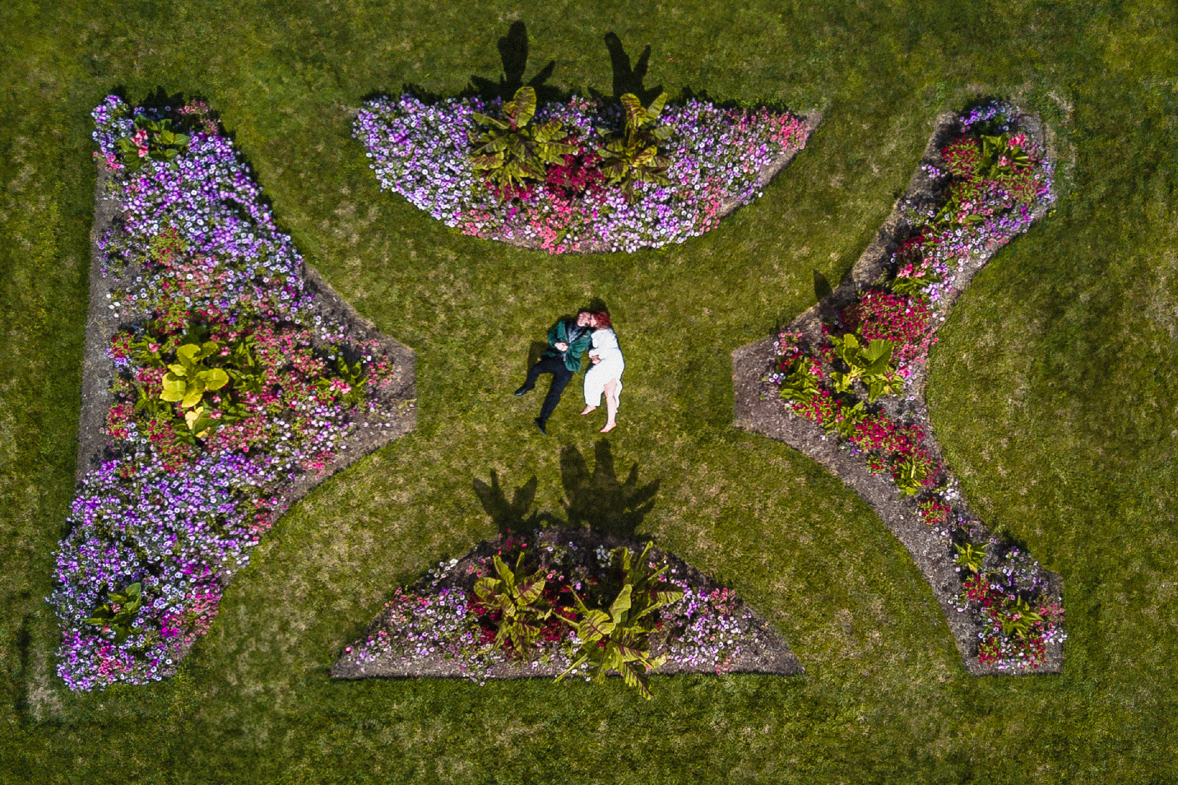 Aerial wedding photography of a couple embraced in a formal garden, captured in Northwest Ohio with an emphasis on symmetry and stillness.