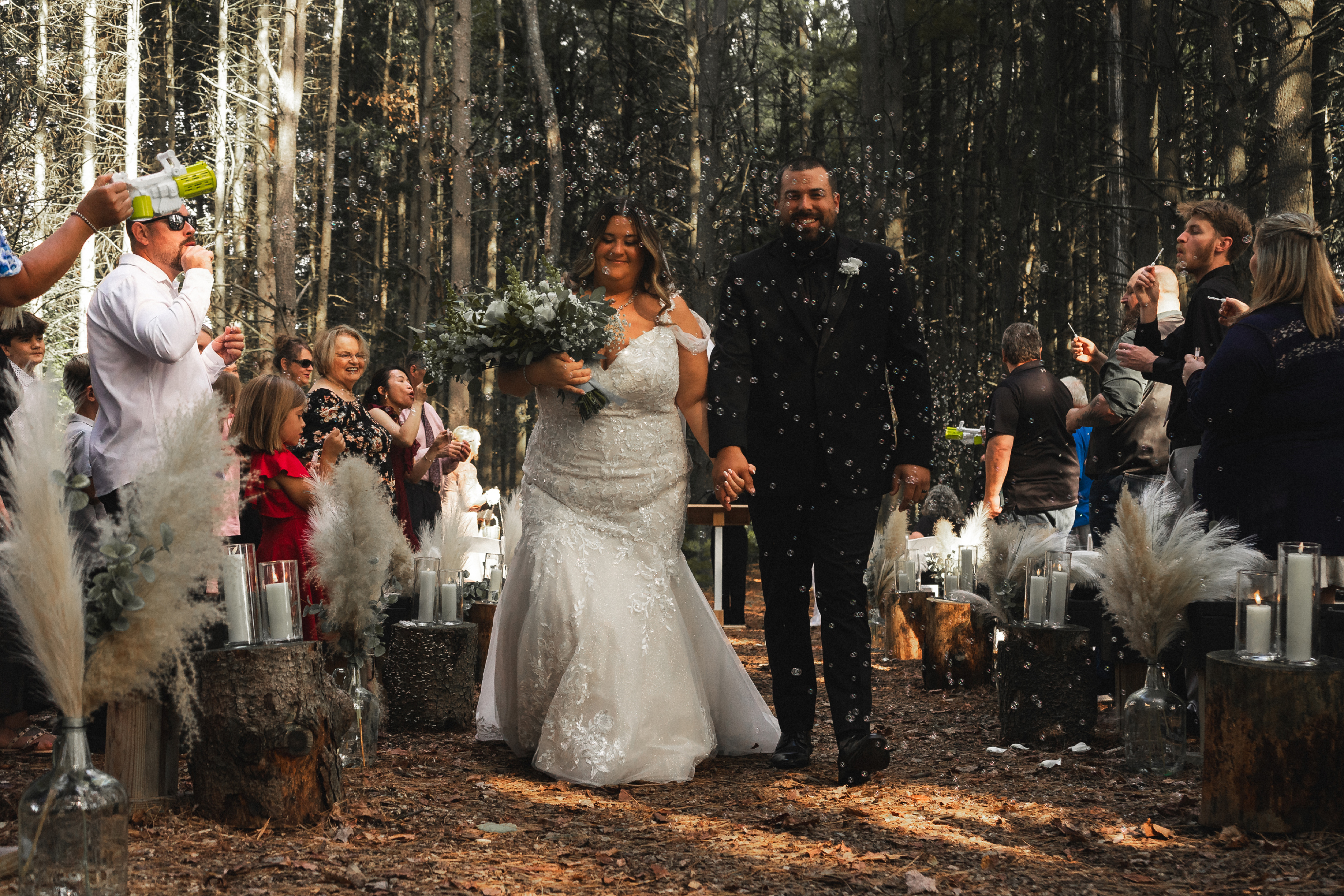 Cinematic forest wedding ceremony in Northwest Ohio, capturing an emotional moment as the couple walks forward surrounded by guests.