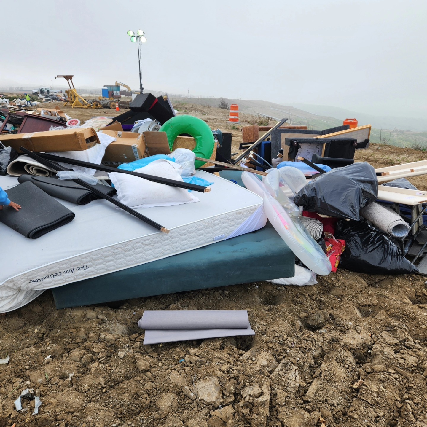 a trash can sitting in the middle of a parking lot