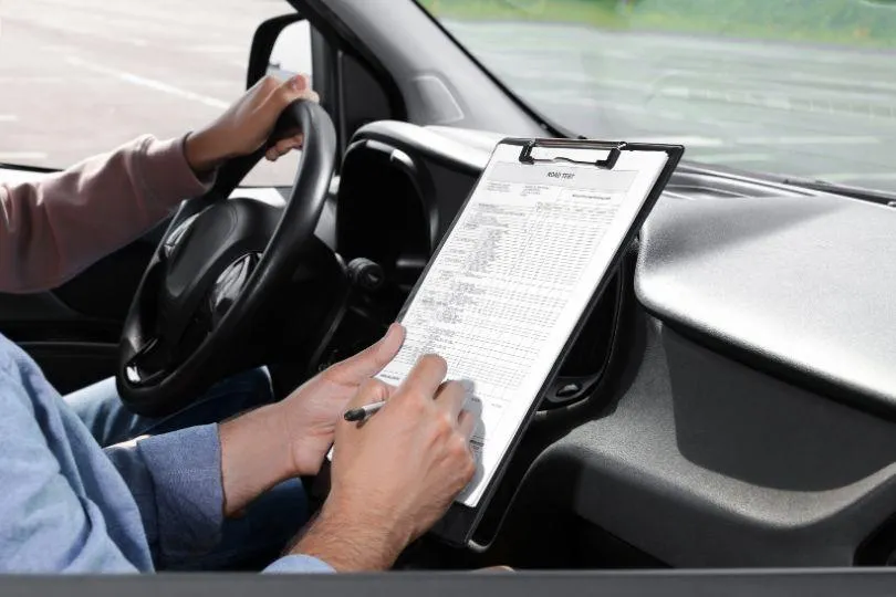 a man sitting in a car with a steering wheel