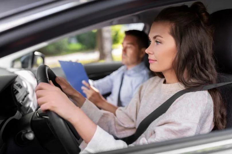 a man sitting in a car with a steering wheel