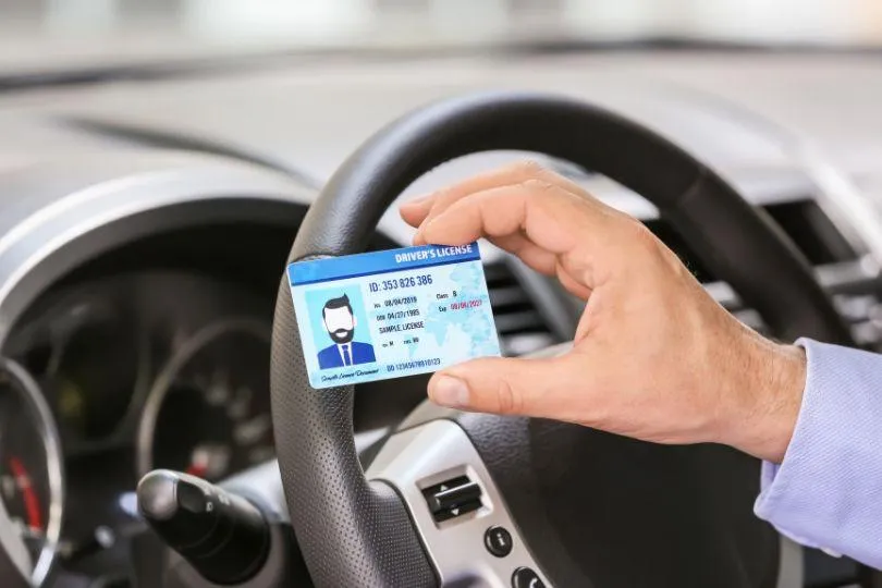 a man sitting in a car with a steering wheel