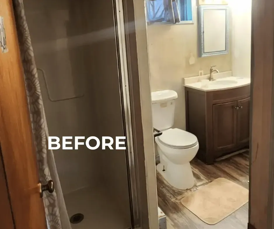 Before view of a small, dated bathroom with a closed shower enclosure, traditional toilet, dark wood vanity with a white sink, and laminate flooring.