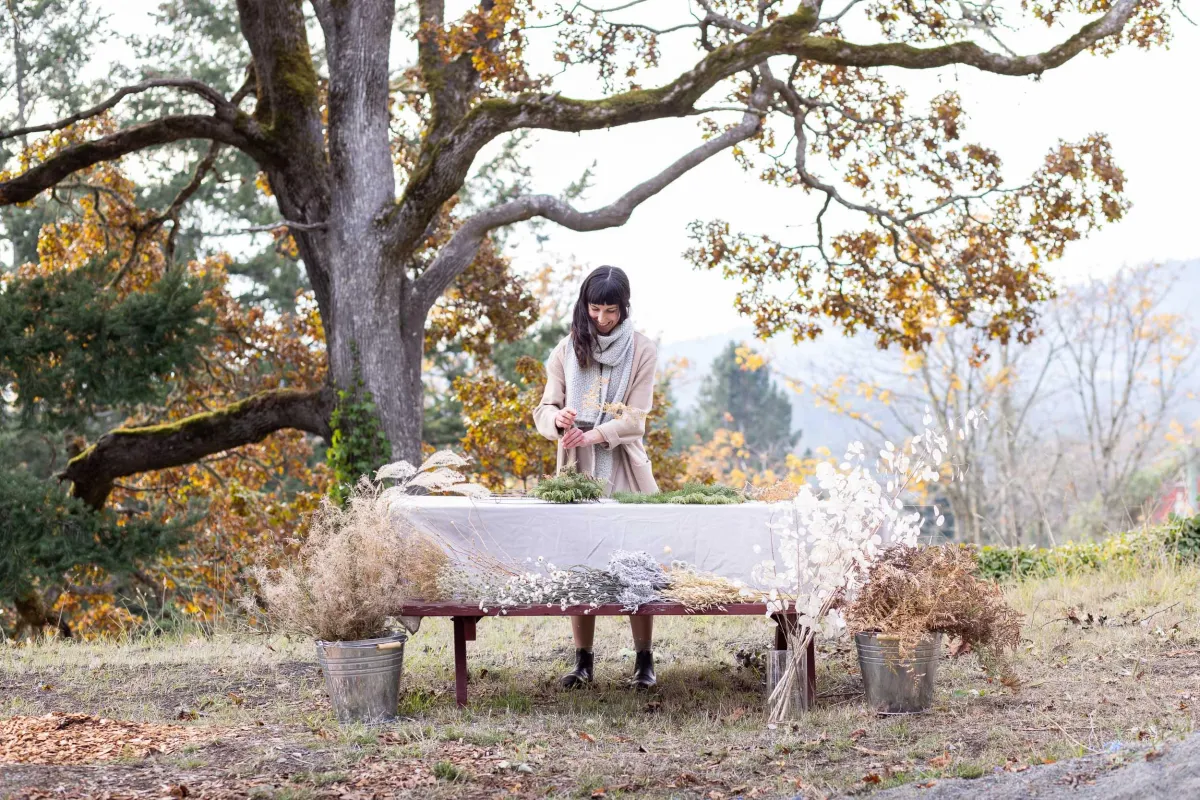 Caitlyn of Deer Leap Florals building a holiday wreath outdoors in Metchosin BC