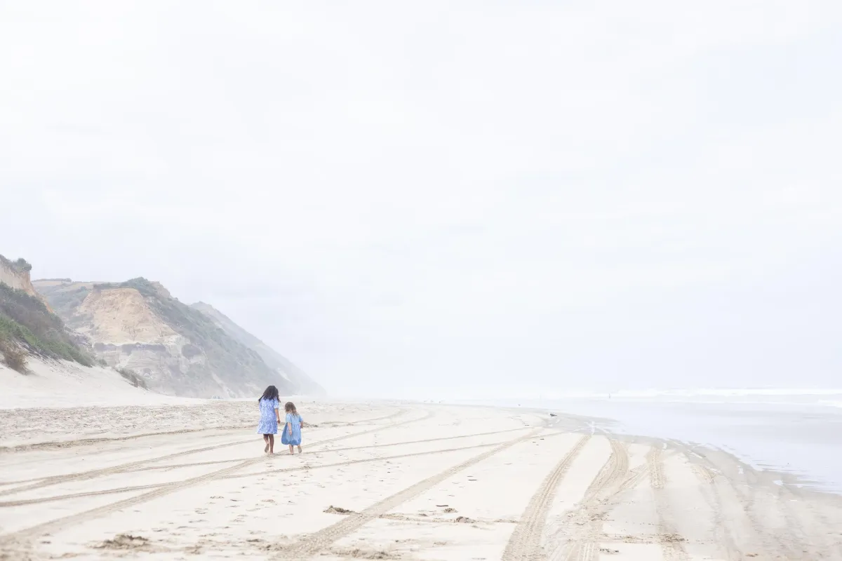 Cousins running on Bayley's Beach in New Zealand