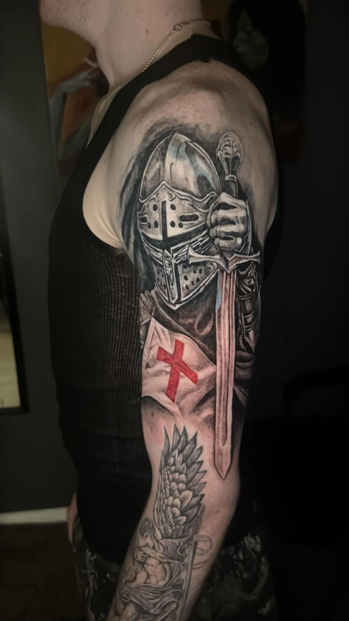 Knight sleeve tattoo Black and grey medieval knight sleeve tattoo with sword and red cross by Nishay Tattoos in Austin