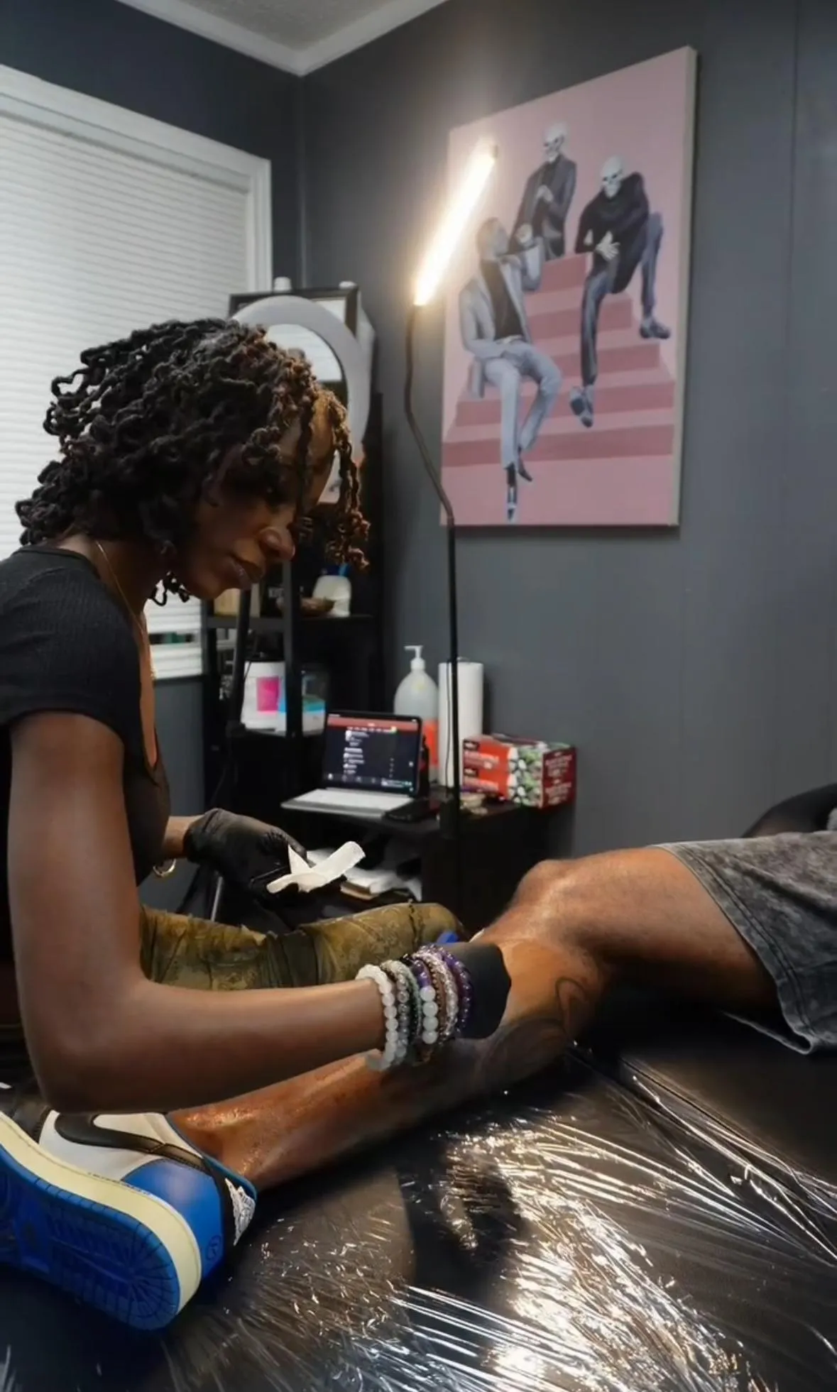 Nishay working with a client during a custom tattoo session in Austin