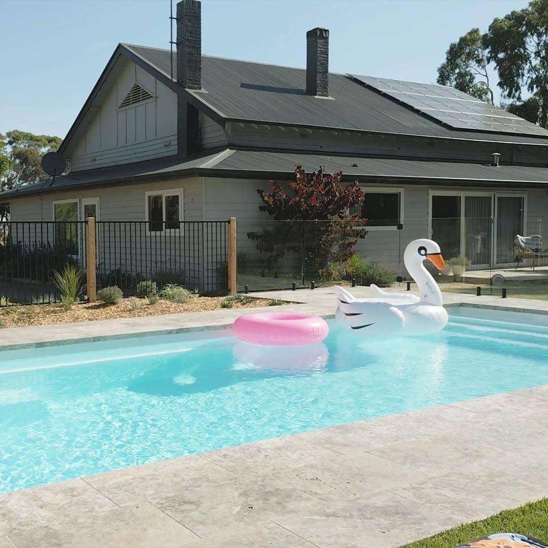 Modern luxury swimming pool with clear aqua water and lounge chairs