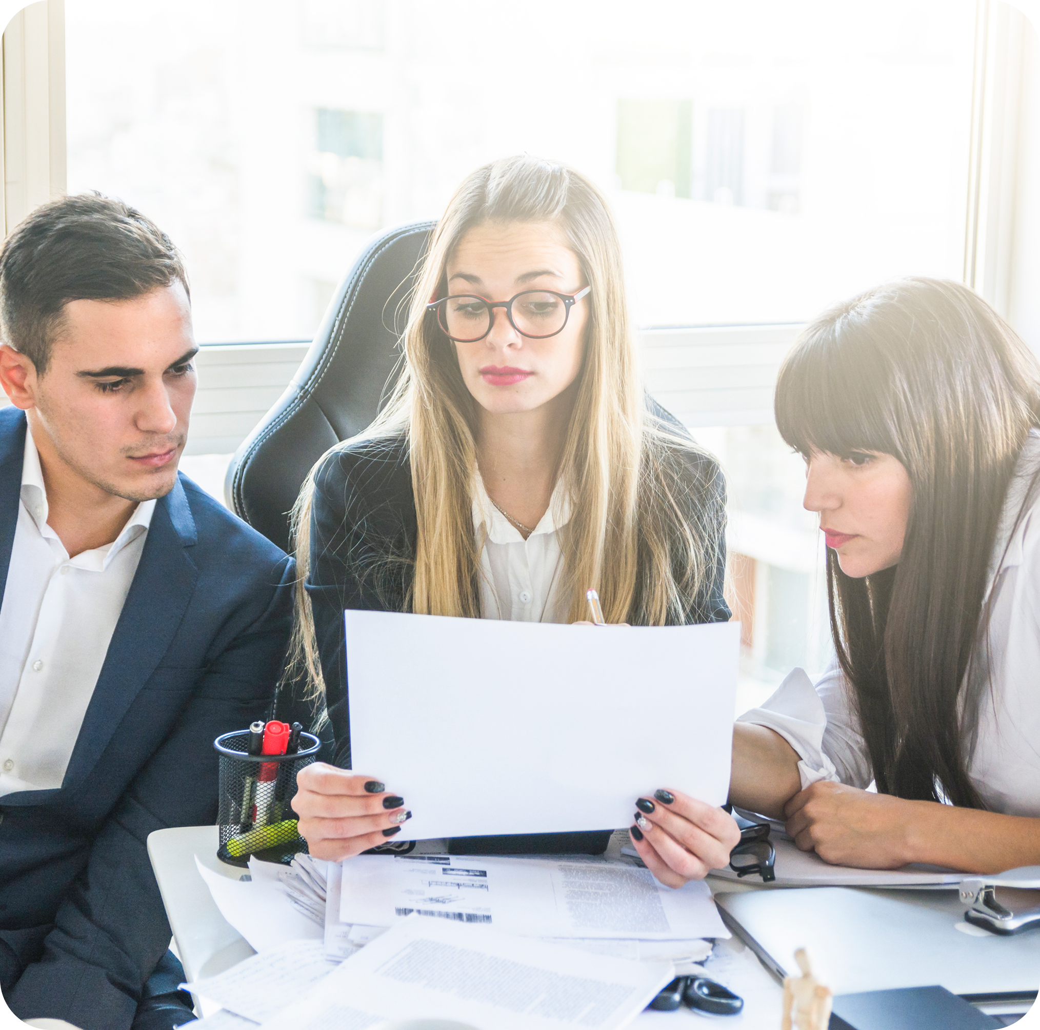 Team of professionals reviewing documents together at a desk, representing collaboration, strategy, and client-focused work with AI Freelance Mastery