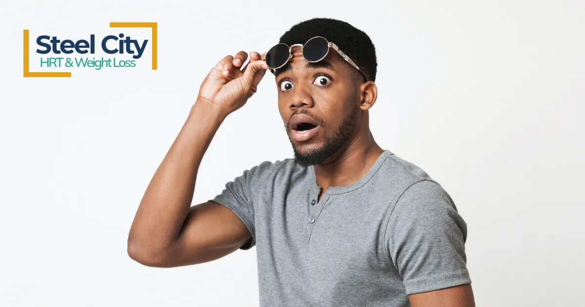 man lifting sunglasses looking surprised
