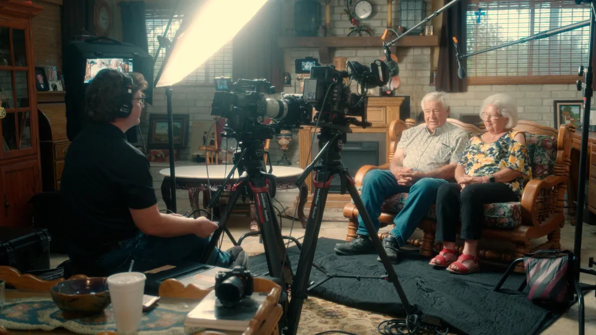 Portrait of a mid-30s Black female filmmaker holding a compact cinema camera, isolated on transparent background