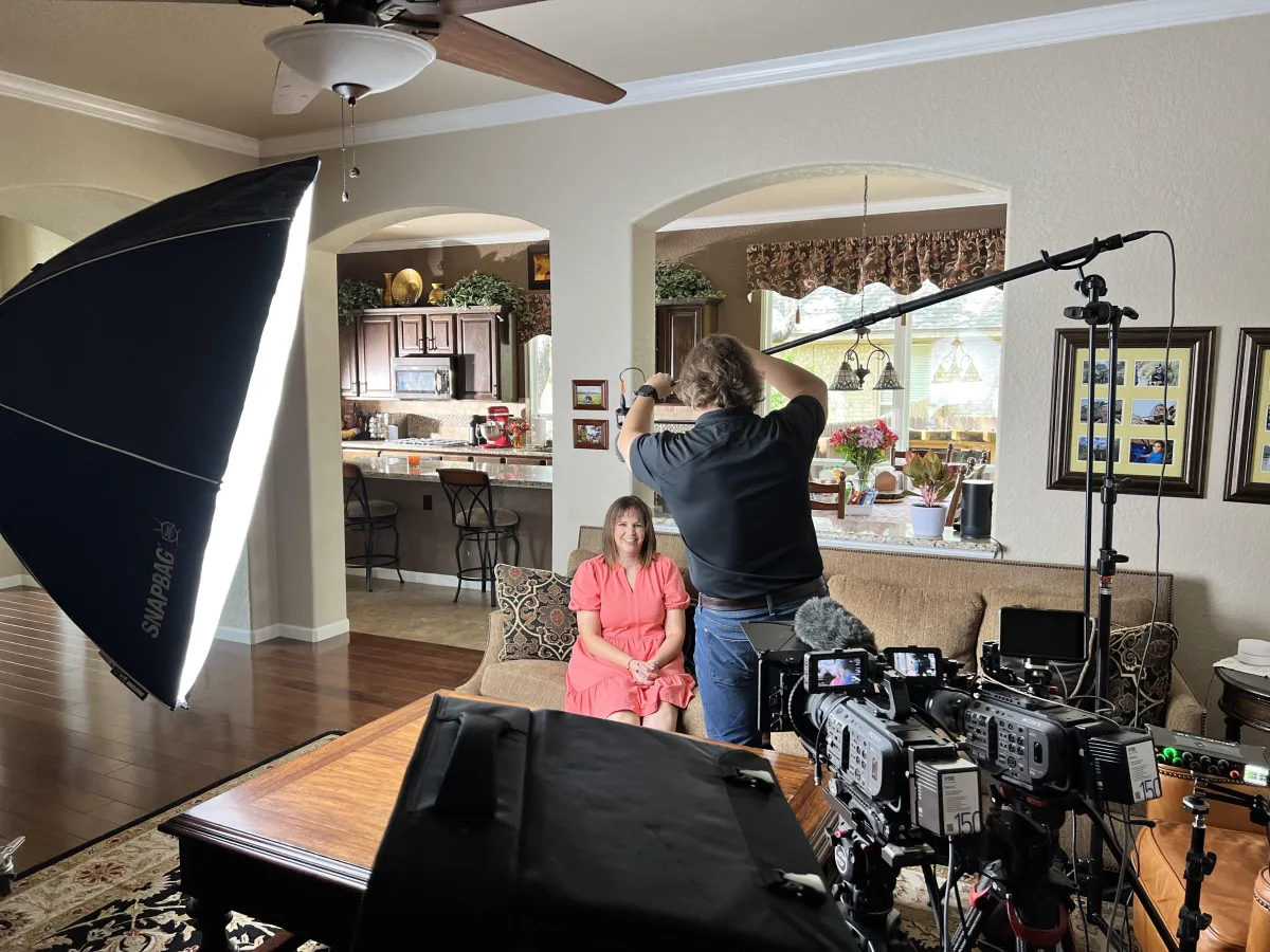 Portrait of a mid-30s Black female filmmaker holding a compact cinema camera, isolated on transparent background