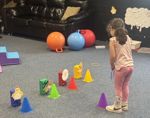 Marisol helping children build with colorful blocks at Aventuras Childcare.