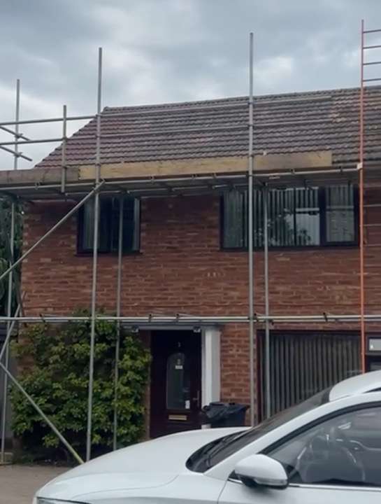 Scaffolding on a semi-detached house during a roof replacement project