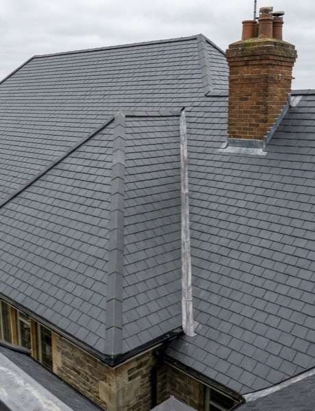 Aerial view of a newly slated residential roof with chimney
