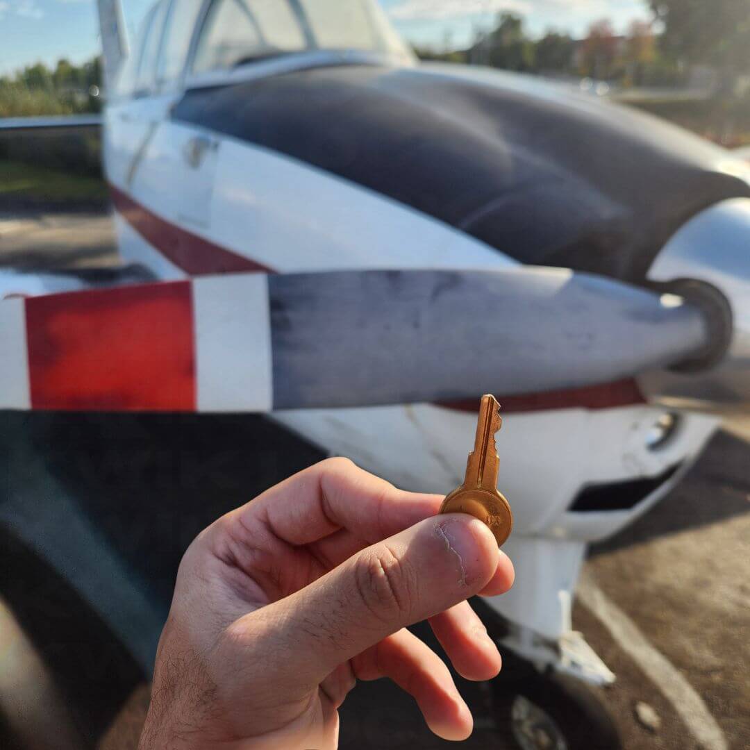 Replacement aircraft key shown in hand near aircraft exterior