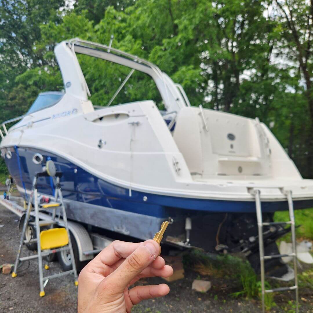 Boat key replacement completed with key in hand near watercraft