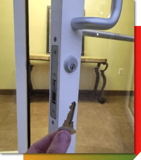 Commercial locksmith servicing a storefront door lock and commercial door hardware