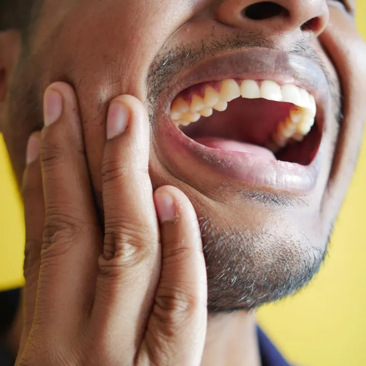 Man holding jaw in dental pain, emergency dental care at Just Wright Dental