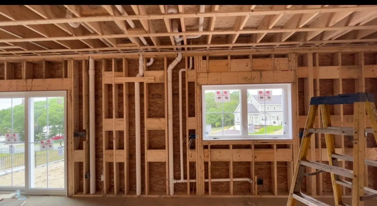 PEX water lines run through wood framing during a new construction plumbing rough-in