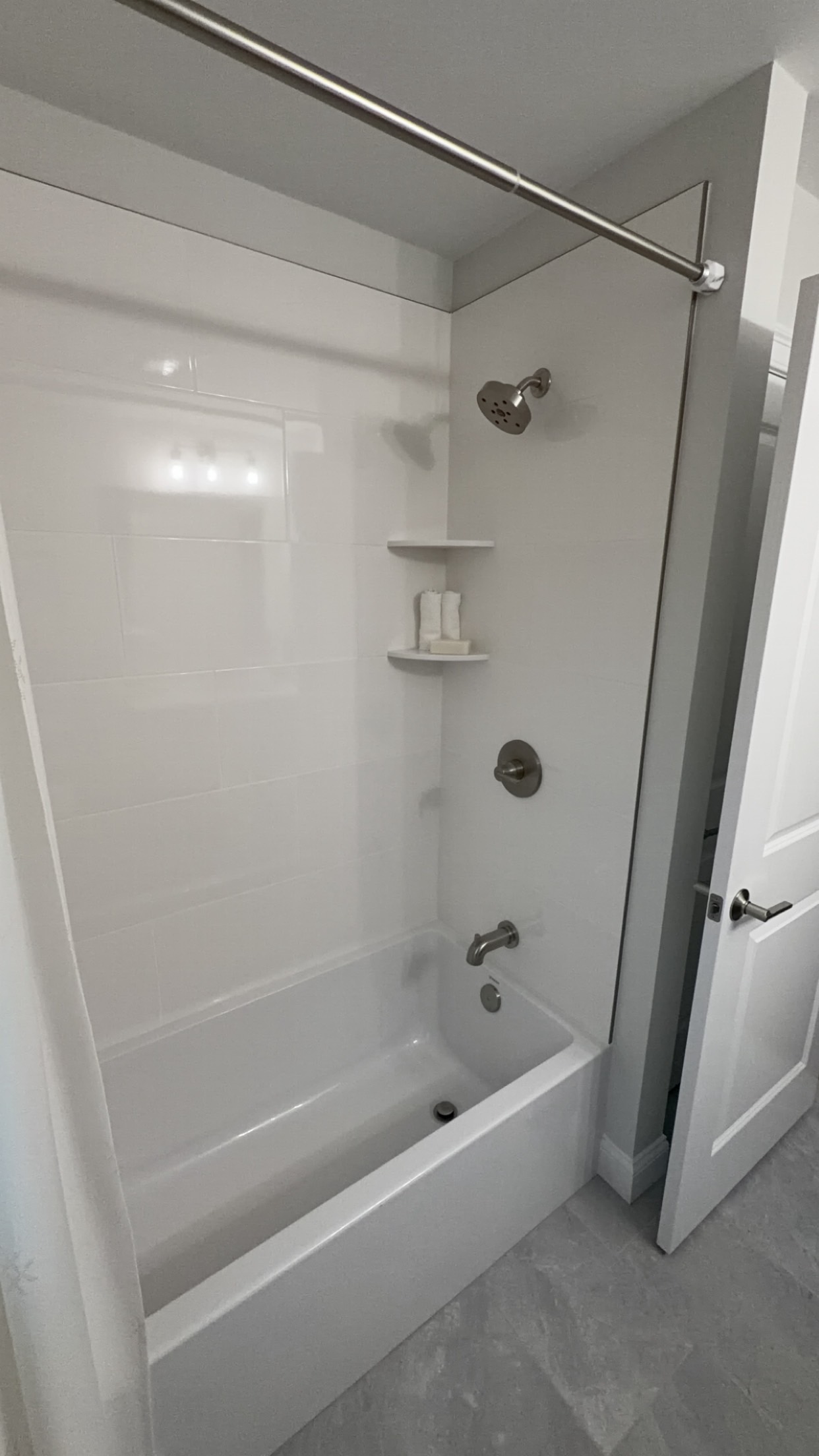 Newly installed tub and shower combination with brushed-nickel fixtures