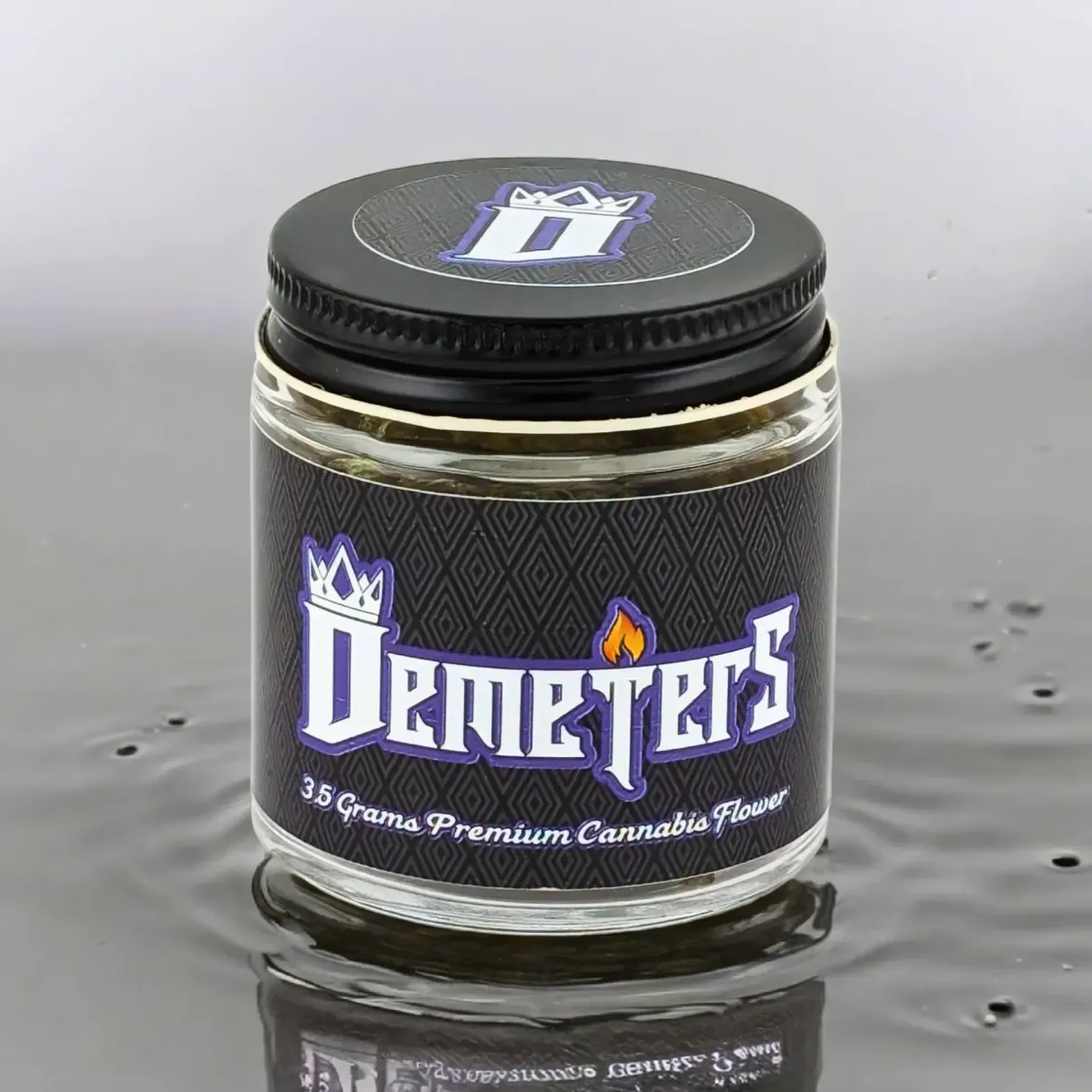 Demeters cannabis flower jar with black label and crown logo, reading “3.5 Grams Premium Cannabis Flower” against reflective surface