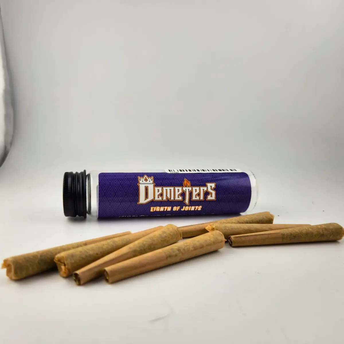 Demeters cannabis pre-rolls displayed in front of a purple branded tube labeled “Eighth of Joints” on white background