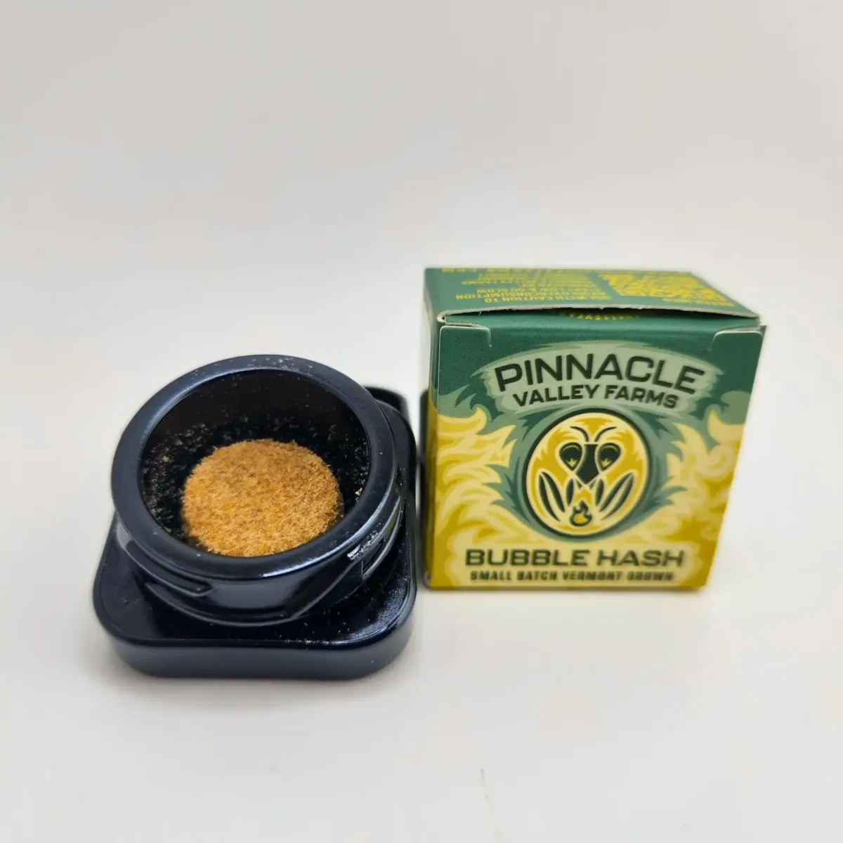 Pinnacle Valley Farms bubble hash cannabis concentrate, small batch Vermont grown, shown in open container with branded box packaging