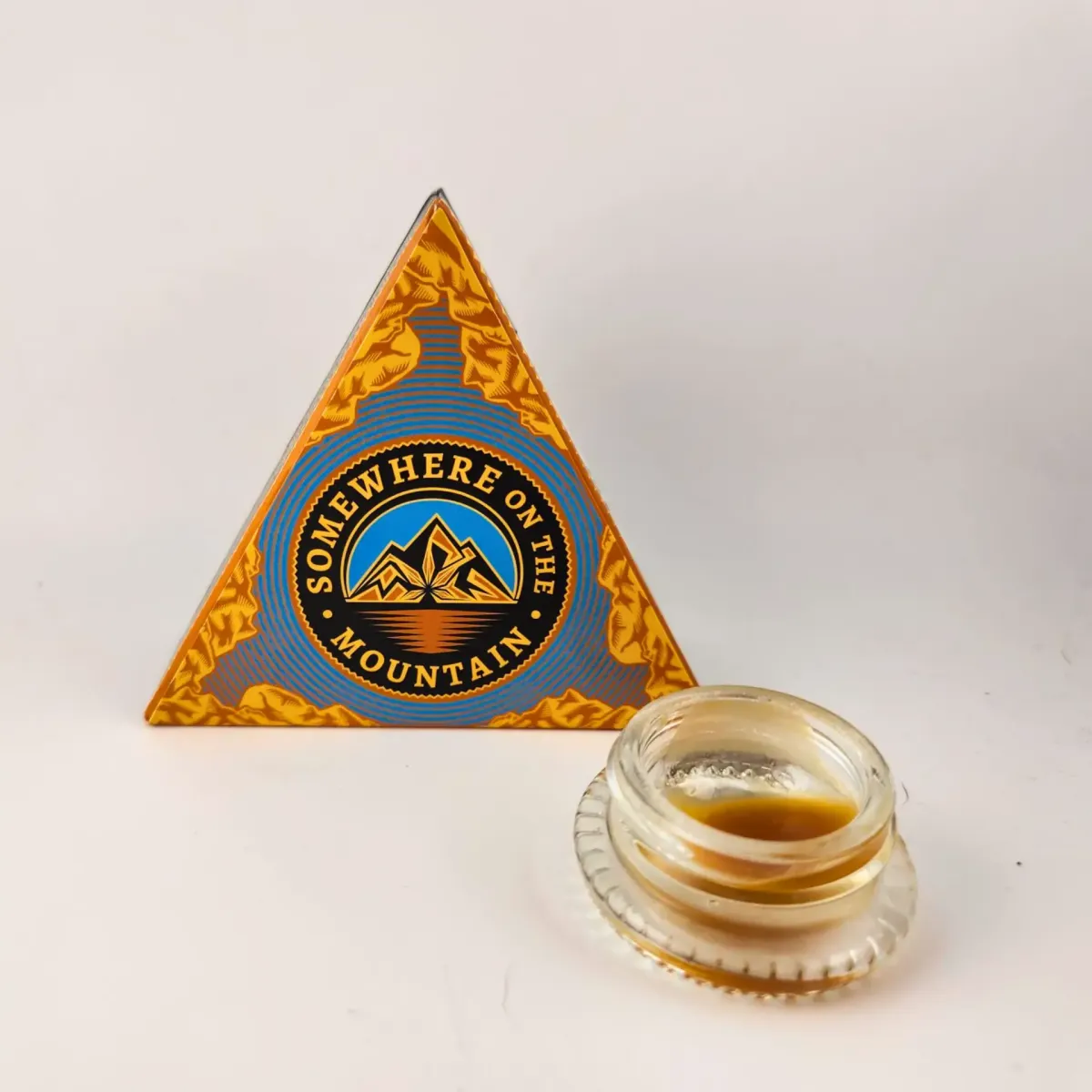 Somewhere on the Mountain cannabis concentrate, packaged in triangular box with glass jar of extract displayed in front