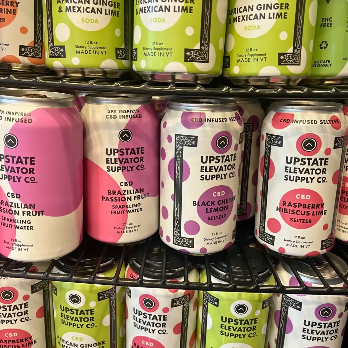 Upstate Elevator Supply Co. CBD beverages on store shelf, including sparkling fruit waters and seltzers in flavors Brazilian Passion Fruit, Black Cherry Lemon, Raspberry Hibiscus Lime, and African Ginger & Mexican Lime.