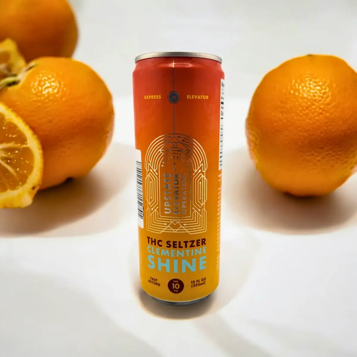 Upstate Elevator Supply Co. THC Seltzer Clementine Shine in 12oz can, 10mg THC, displayed with fresh oranges in the background.