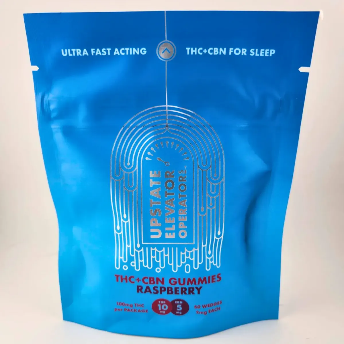 Upstate Elevator Operator THC+CBN Raspberry Gummies, cannabis edibles for sleep with 100mg THC and 50 wedges at 2mg each, packaged in a blue resealable bag.