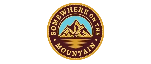 Somewhere on the Mountain logo featuring stylized golden mountains above a reflective lake within a circular badge design.