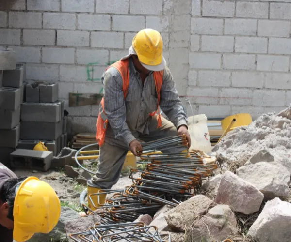 Skilled builder in Karachi engaged in masonry work on a new commercial construction project.