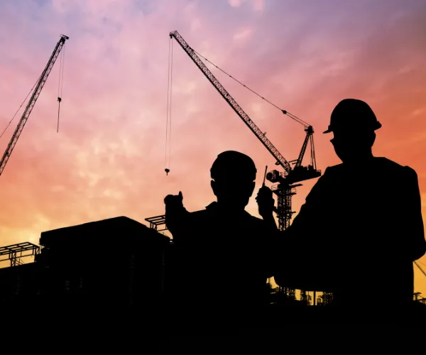 Construction professional in Multan installing roofing on an upcoming shopping center.