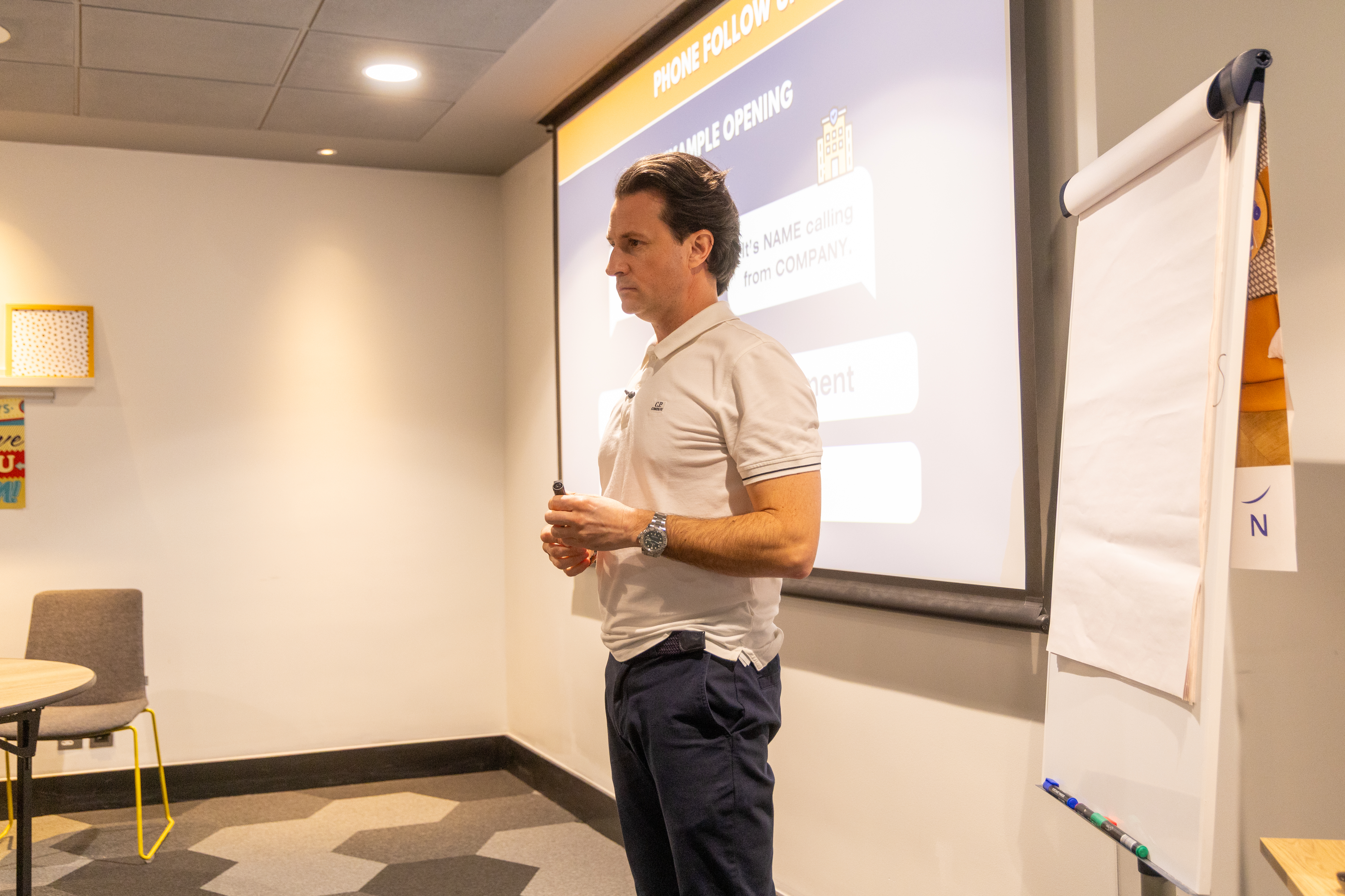 Jamie Burrows speaking to a group in a modern boardroom