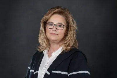 Professional headshot of Diane C. Clyburn, Commercial Account Manager at Centurion Insurance Services, wearing glasses and a dark sweater over a white blouse, posed against a dark background.