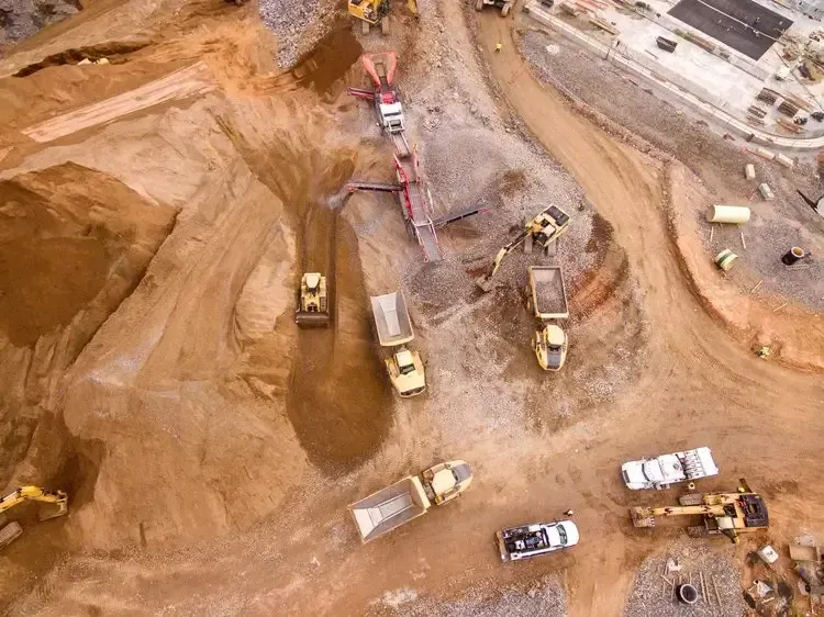 Aerial view of a large mining or construction site with trucks and heavy machinery, illustrating Centurion Insurance Services’ partnerships across the energy and manufacturing industries.