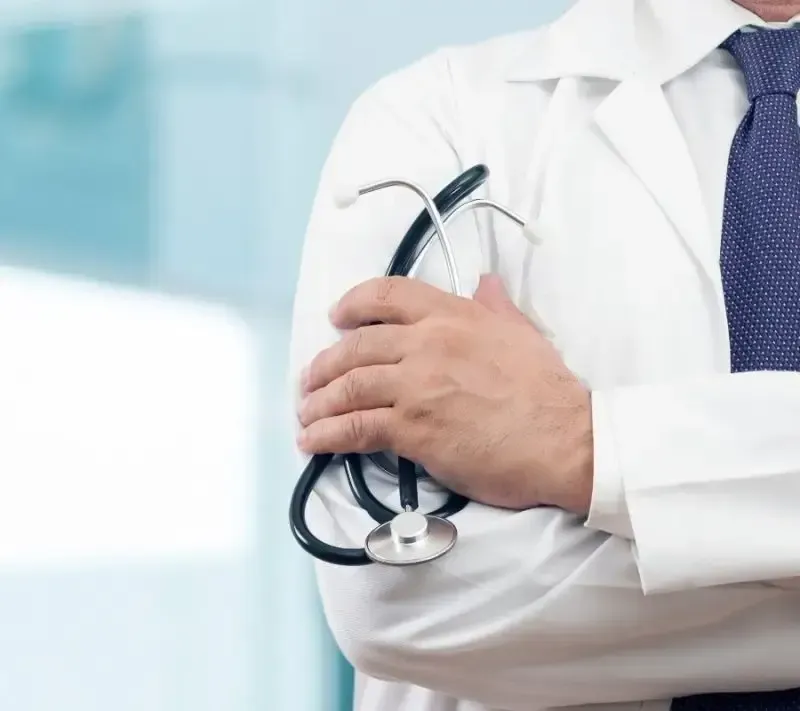 Close-up of a physician in a white coat holding a stethoscope, symbolizing Centurion Insurance Services’ medical malpractice and professional liability coverage for healthcare professionals.