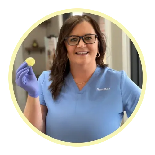 Smiling woman in scrubs holding a ball of sugaring paste, promoting sugar hair removal techniques for skincare professionals.