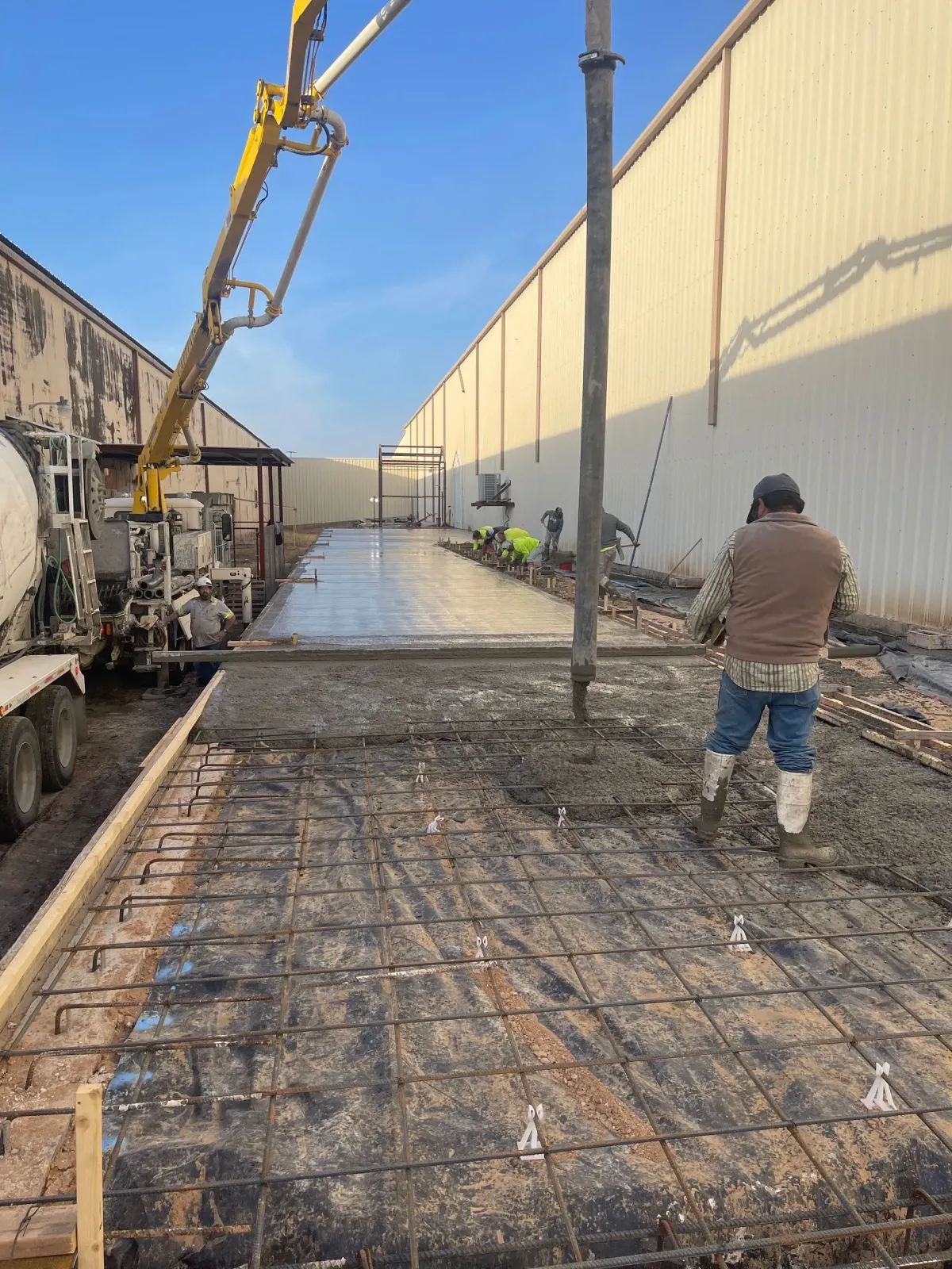 Commercial concrete pour on the side of a metal building