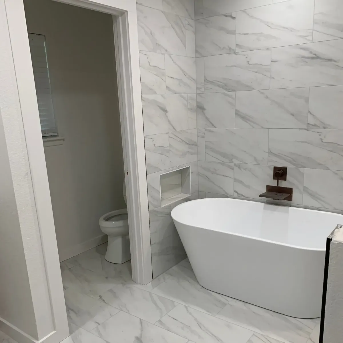 Bathroom remodel with floor to wall white tile
