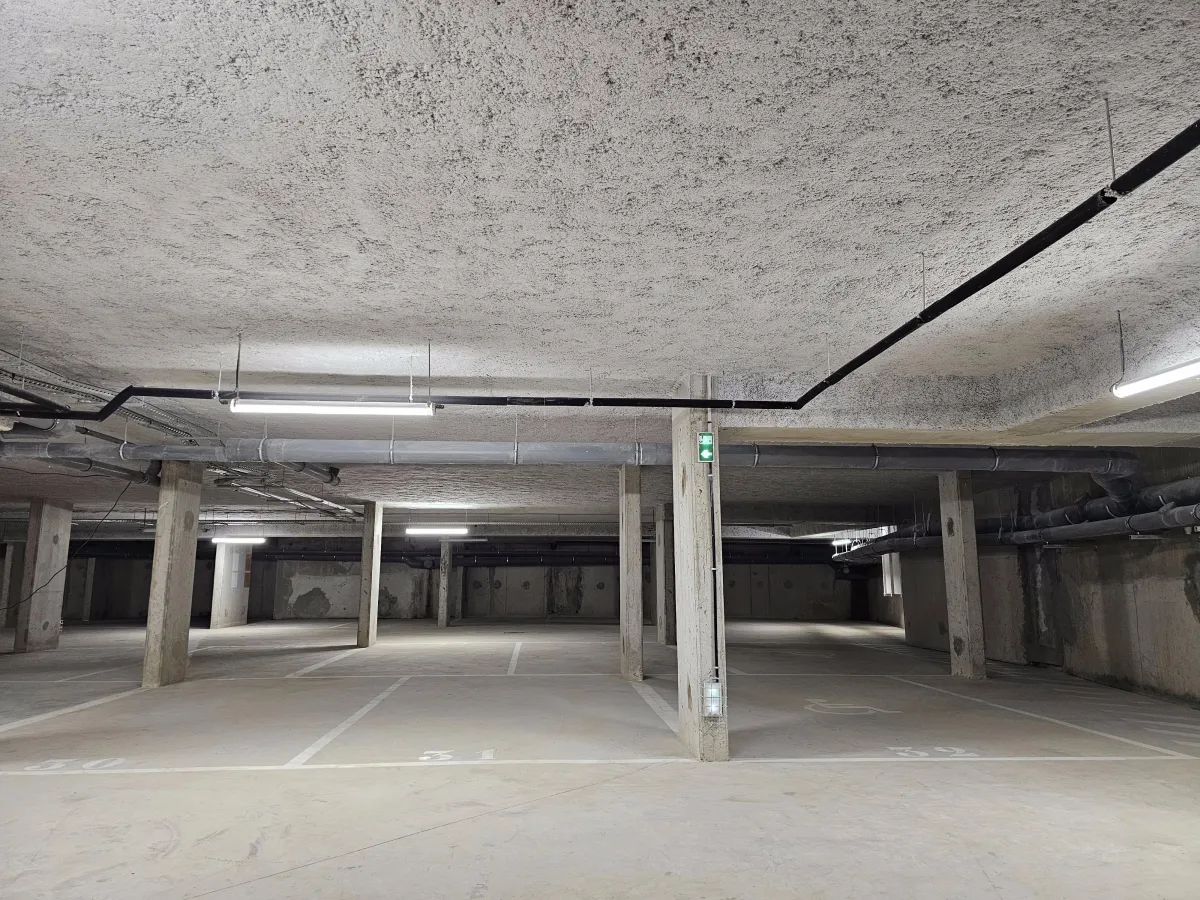 Flocage projeté coupe-feu et thermique réalisé au plafond d’un parking souterrain – isolation passive et protection incendie