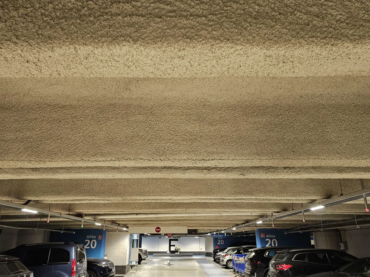 Flocage pâteux coupe-feu 2 heures projeté sous plafond béton de l’aéroport Charles de Gaulle en région parisienne – ERBI
