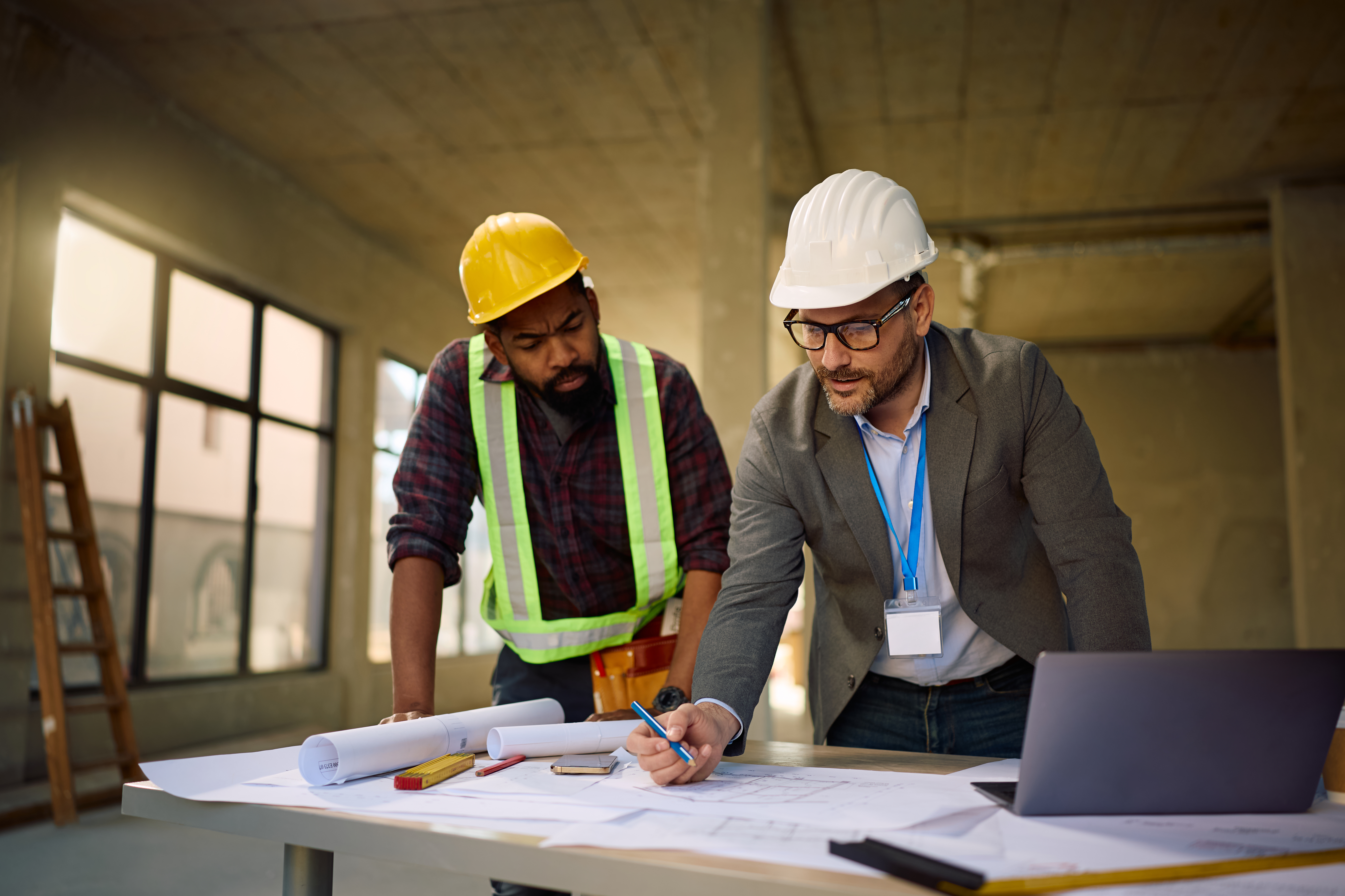 Construction business owner reviewing project dashboards with advisor